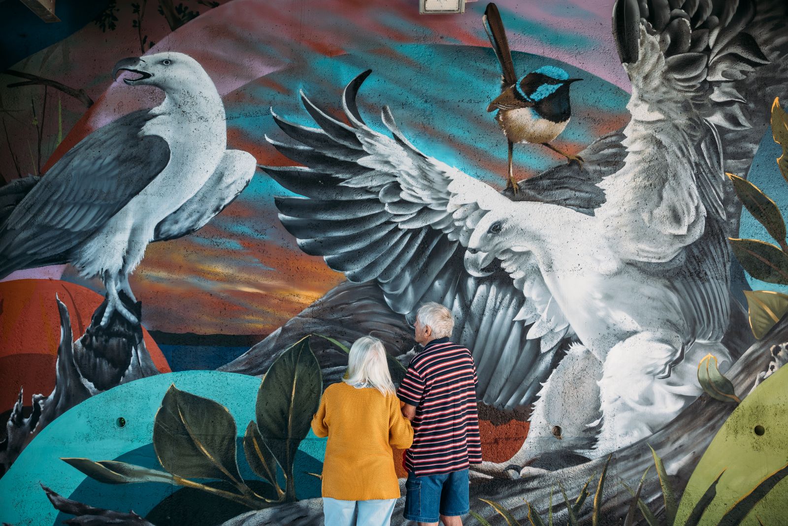 couple standing in front of mural banner image