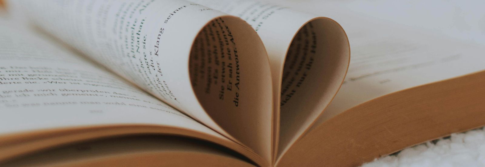 Book with pages folded into heart shape banner image