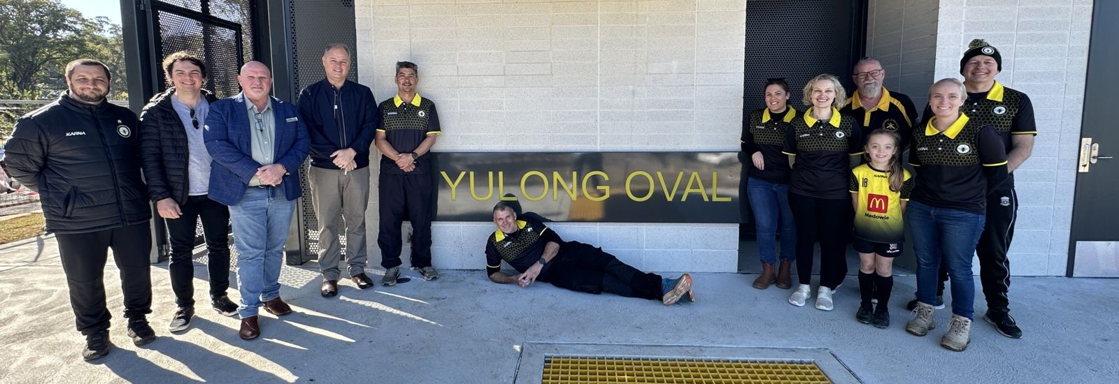 Yulong Oval amenities building with Councillors and Medowie Football Club Committee members banner image