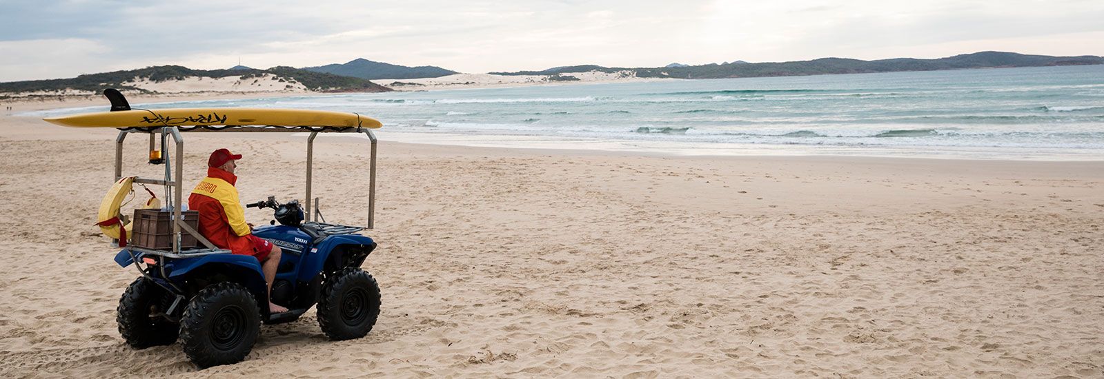 surf life saver on buggy on beach banner image