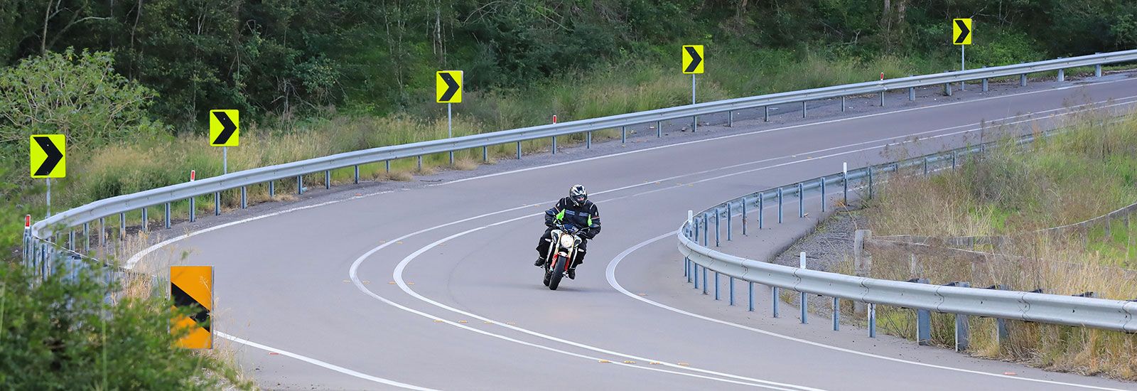 motorcycle riding on an empty road banner image