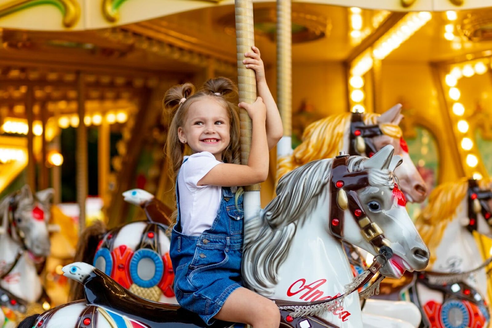 girl sitting on a carousel banner image